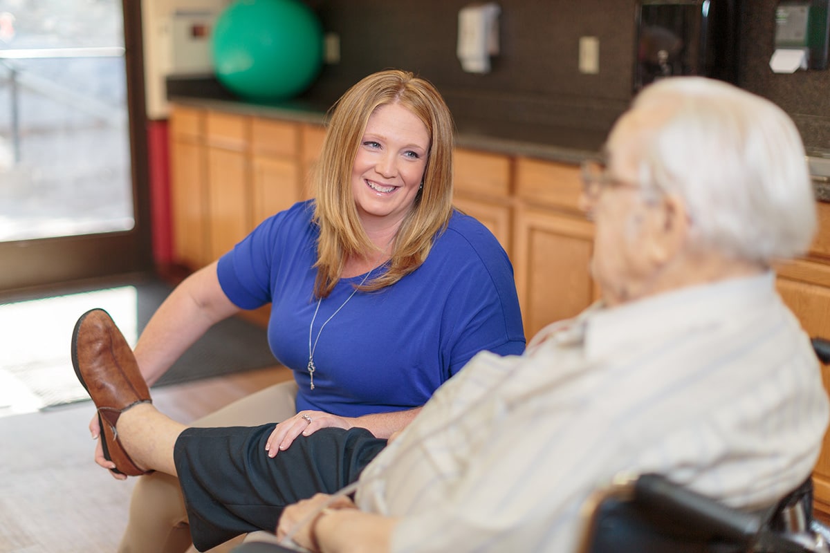 Female therapist stretching an elderly's leg