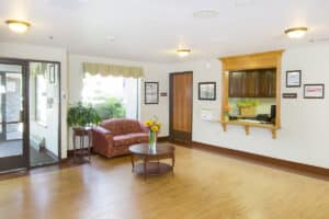 Spacious lobby with a red sofa, a vase of sunflowers, and a receptionist window
