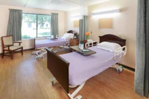 Room with two beds and curtains for privacy with a large window