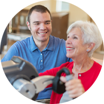 female patient wearing a bright red top and red lipstick smiling while exercising